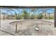 Enclosed pool area with grey brick floor, tropical garden, and metal screening under a bright blue sky at 232 Bahia Vista Dr, Englewood, FL 34223