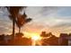 Beautiful waterfront sunset framed by palm trees, docks, and coastal foliage at 232 Bahia Vista Dr, Englewood, FL 34223
