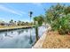 Serene waterfront view of the canal with tropical foliage, and a glimpse of houses with screened-in pools at 232 Bahia Vista Dr, Englewood, FL 34223