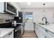 Modern kitchen with stainless steel appliances, granite countertops and white cabinets at 2375 N Beach Rd # 2B, Englewood, FL 34223