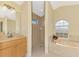 Bright bathroom featuring a standalone shower, soaking tub, and vanity with tan countertops at 43 Blue Hen Dr, Placida, FL 33946