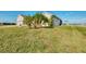 Home exterior showcasing the well-maintained lawn, palm trees, and waterfront location at 43 Blue Hen Dr, Placida, FL 33946