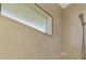Close-up of shower with beige tile surround, a window, and a chrome shower head at 43 Blue Hen Dr, Placida, FL 33946