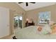 Bedroom with fan, neutral paint, dresser, slider to private screened balcony overlooking water at 4754 Club Dr # 201, Port Charlotte, FL 33953