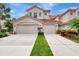 Two-story townhome featuring a red tile roof, neutral stucco, and a two-car garage enhancing curb appeal at 4754 Club Dr # 201, Port Charlotte, FL 33953