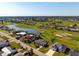Aerial view of a house with a pool surrounded by lush golf courses and scenic lakes at 84 Caddy Rd, Rotonda West, FL 33947