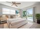 Bright main bedroom featuring a large bed, a sliding glass door leading to a pool, and neutral paint at 84 Caddy Rd, Rotonda West, FL 33947
