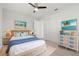 Cozy bedroom featuring a wicker bedframe, matching end tables and dresser, and coastal themed artwork at 84 Caddy Rd, Rotonda West, FL 33947