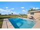Private in-ground pool with lush backyard landscape and a comfortable outdoor seating area at 84 Caddy Rd, Rotonda West, FL 33947