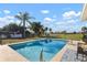Private in-ground pool surrounded by lush landscaping with a beautiful outdoor seating area at 84 Caddy Rd, Rotonda West, FL 33947