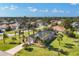 Home boasts a well-manicured lawn, mature palm trees, and a long driveway at 100 Hobo Rd, Rotonda West, FL 33947