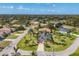 Aerial view of a single-Gathering home with a well-manicured lawn, palm trees, and mature landscaping at 100 Hobo Rd, Rotonda West, FL 33947