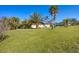 Large backyard space offering green grass, mature trees, and a peaceful outdoor atmosphere at 100 Hobo Rd, Rotonda West, FL 33947