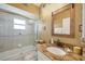 Bathroom with a glass-enclosed tub/shower, granite counters, and neutral decor at 100 Hobo Rd, Rotonda West, FL 33947