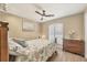 Bedroom with ceiling fan, wood floors, shuttered window and neutral decor at 100 Hobo Rd, Rotonda West, FL 33947