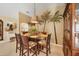 Dining area with a glass-top table, palm tree mural, and stylish lighting, offering a comfortable and elegant dining space at 100 Hobo Rd, Rotonda West, FL 33947