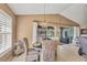 Open dining area with wicker chairs, modern light fixture, and large window overlooking the backyard pool at 100 Hobo Rd, Rotonda West, FL 33947