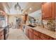 Kitchen with wooden cabinets, granite countertops, black sink, stainless steel dishwasher, and tile flooring at 100 Hobo Rd, Rotonda West, FL 33947