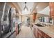Spacious kitchen with stainless steel appliances, wooden cabinets, adjacent dining area, and tiled floors at 100 Hobo Rd, Rotonda West, FL 33947