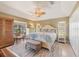 Well-lit main bedroom featuring a decorative fan, tile floors, and comfortable furnishings at 100 Hobo Rd, Rotonda West, FL 33947