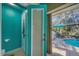 Bright, teal-colored pool bathroom with direct access to the lanai and pool at 100 Hobo Rd, Rotonda West, FL 33947