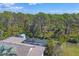 An aerial view showcases a screened-in pool and the roof against a backdrop of lush trees at 1087 Bay Harbor Dr, Englewood, FL 34224