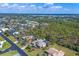 An aerial view showing neighborhood, nearby green spaces, and clear blue skies at 1087 Bay Harbor Dr, Englewood, FL 34224