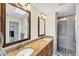 Bathroom with double vanity, granite counters, framed mirrors, and a glass enclosed shower at 1087 Bay Harbor Dr, Englewood, FL 34224