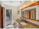 Bathroom featuring granite counters, wooden cabinets, and stylish pendant lighting at 1087 Bay Harbor Dr, Englewood, FL 34224