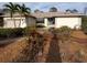 Charming single-story home featuring mature landscaping and a welcoming blue front door at 1087 Bay Harbor Dr, Englewood, FL 34224