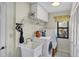 Bright laundry room with washer, dryer, utility sink and storage cabinets at 1087 Bay Harbor Dr, Englewood, FL 34224