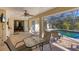 Covered patio area with table and chairs, perfect for outdoor dining, leading to a screened pool at 1087 Bay Harbor Dr, Englewood, FL 34224