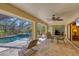 Serene screened patio with a sparkling pool and hot tub, surrounded by lush greenery and comfortable seating at 1087 Bay Harbor Dr, Englewood, FL 34224