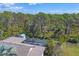 Aerial view of a screened in pool, surrounded by lush tropical foliage and mature trees at 1087 Bay Harbor Dr, Englewood, FL 34224