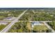 Aerial view of neighborhood surrounded by trees with a home with a pool in the center at 13354 Blytheville Ave, Port Charlotte, FL 33981