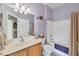 Bathroom featuring a combination shower and tub, vanity with sink, toilet, and a bright purple paint at 13354 Blytheville Ave, Port Charlotte, FL 33981