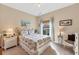 Charming bedroom with a queen bed with floral bedding, side table, and bright window view at 13354 Blytheville Ave, Port Charlotte, FL 33981