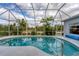 Screened-in in-ground pool featuring a metal handrail at 13354 Blytheville Ave, Port Charlotte, FL 33981