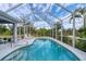 Screened in swimming pool with lounge chairs and tropical landscaping around the backyard at 13354 Blytheville Ave, Port Charlotte, FL 33981