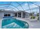 Screened in swimming pool surrounded by lounging chairs and overlooking the backyard at 13354 Blytheville Ave, Port Charlotte, FL 33981