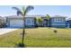Charming single-story home with a well-manicured lawn and attached garage at 15610 Seafoam Cir, Port Charlotte, FL 33981