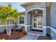 Inviting front entrance with double doors, decorative archway, and lush landscaping at 15610 Seafoam Cir, Port Charlotte, FL 33981