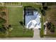 Beautiful property with manicured lawns, a screened pool, and a circular driveway at 15691 Meacham Cir, Port Charlotte, FL 33981