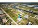 Aerial view of a waterfront home, featuring lush landscaping, a paved driveway, and an attached two-car garage at 15691 Meacham Cir, Port Charlotte, FL 33981