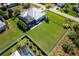 Aerial view of a spacious backyard with lush green grass, modern fencing, and mature trees at 15691 Meacham Cir, Port Charlotte, FL 33981