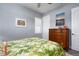 Bright bedroom featuring warm wood dresser, plantation shutters, and tropical inspired artwork at 15691 Meacham Cir, Port Charlotte, FL 33981