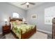 Cozy bedroom with ceiling fan, complemented by tropical themed comforter and decorative lamps at 15691 Meacham Cir, Port Charlotte, FL 33981