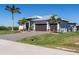 Stunning two-story home boasts a paver driveway, three-car garage, metal roof and mature palm trees at 15691 Meacham Cir, Port Charlotte, FL 33981