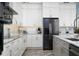 Bright kitchen features white cabinets, stainless steel appliances, tile backsplash, and modern fixtures at 15691 Meacham Cir, Port Charlotte, FL 33981