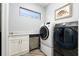 Modern laundry room equipped with front loading washer and dryer at 15691 Meacham Cir, Port Charlotte, FL 33981